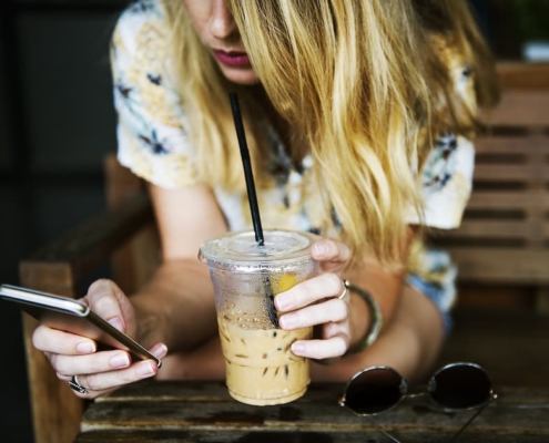 Eine Frau nutzt ihr Smartphone für eine lokale Googlesuche nach einem nahegelegenen Friseursalon